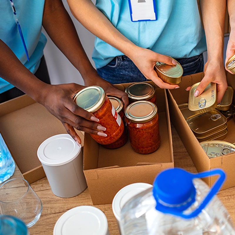 Need Assistance? Volunteers sorting canned goods.
