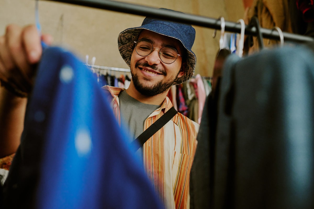 Person looking through thrift store clothing.